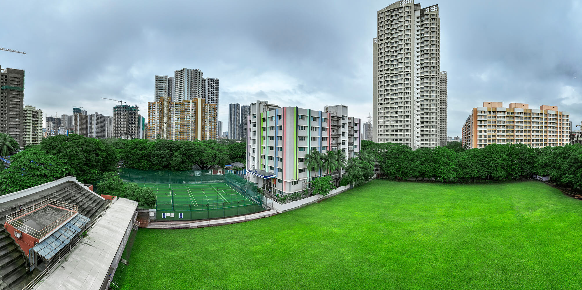 Hridgandha mistry panorama 3 Panoramic view of a green urban school ground surrounded by residential high-rises in Mumbai.